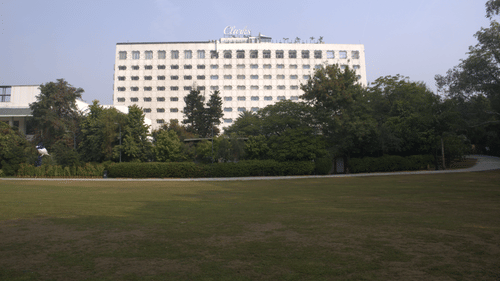 A wide view of the hotel exterior overlooking expansive landscaped lawns, showcasing the property's setting for weddings and outdoor celebrations | Clarks Amer, Jaipur