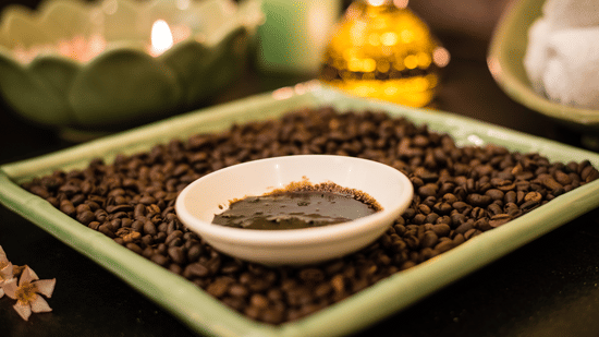 A plate of coffee kept next to candles at The Serai Chikmagalur