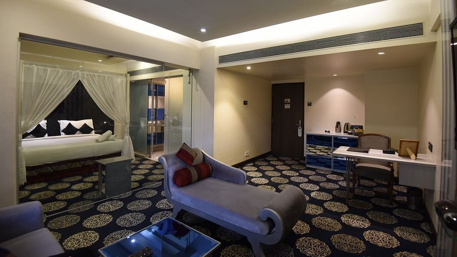 a double bed with a sofa also in view inside one of the rooms - VITS Sharanam Thane
