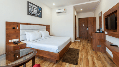 Premium room featuring a tea and coffee maker, air-conditioning, and a Buddha portrait above the bed at DLS The Classio