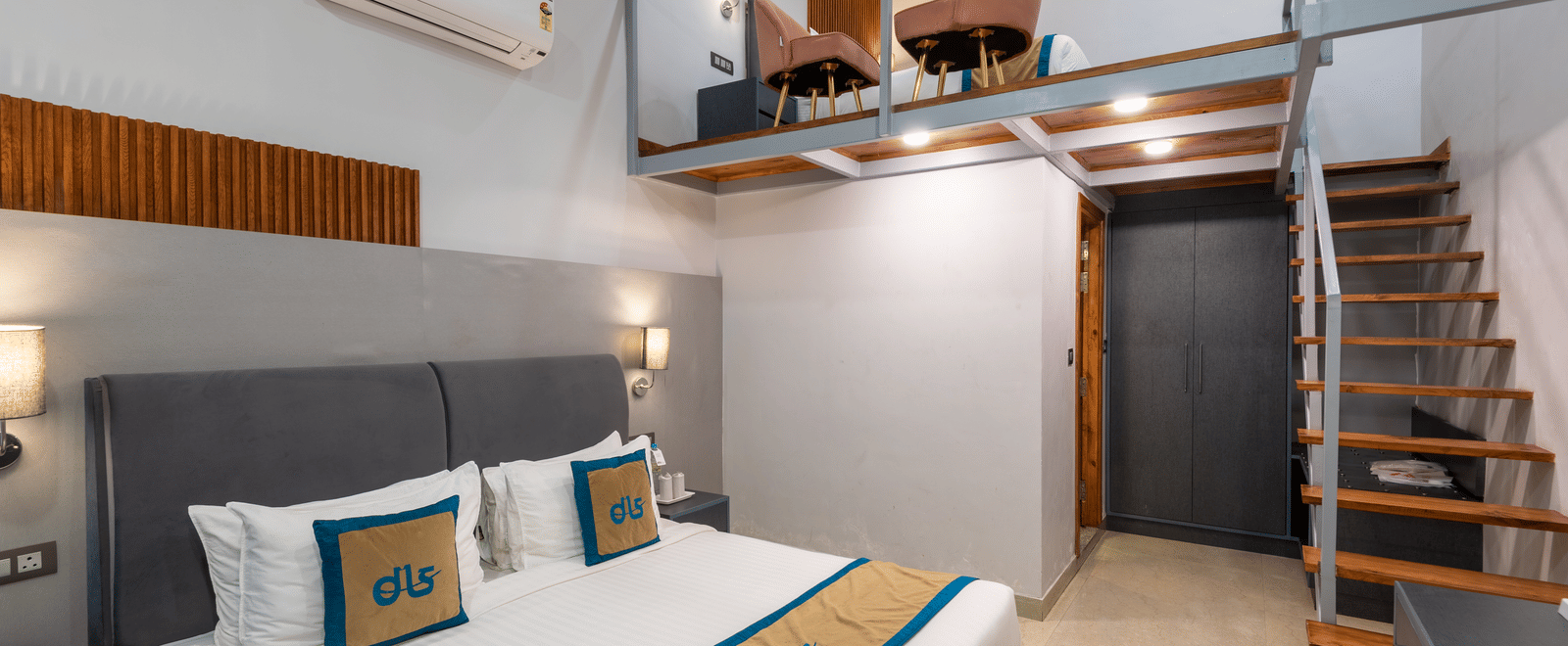 Spring Duplex Room at DLS Spring Valley resort Dharamshala featuring a king bed table, chairs and stairs leading to second story