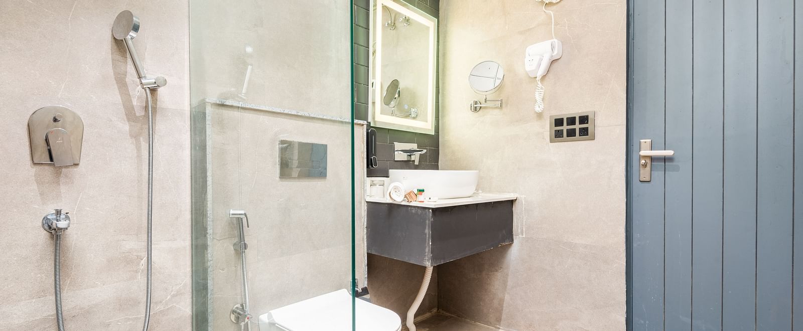 Bathroom of Luxury Cottage at DLS Divine River Resort and  Spa featuring shower, sink area, mirror and a toilet.