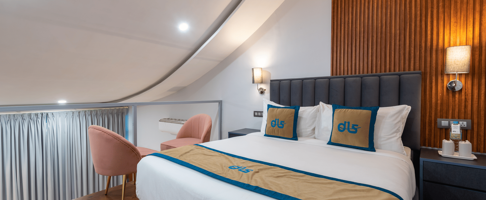 Spring Duplex Room at DLS Spring Valley resort Dharamshala on the second story featuring a king bed table, chairs and a bed lamp