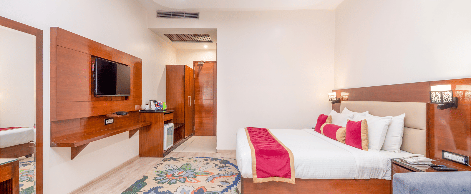 Spacious suite with bed, sofa, and TV at DLS Hotels On The Ganges.