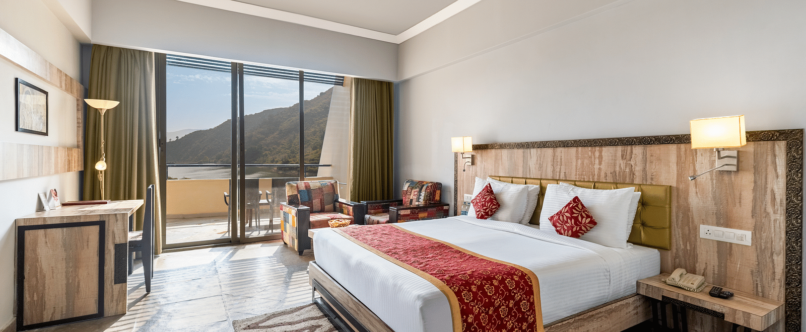 A wide angle shot of a bed with a runner on it and a large window - Via Lakhela Resort & Spa