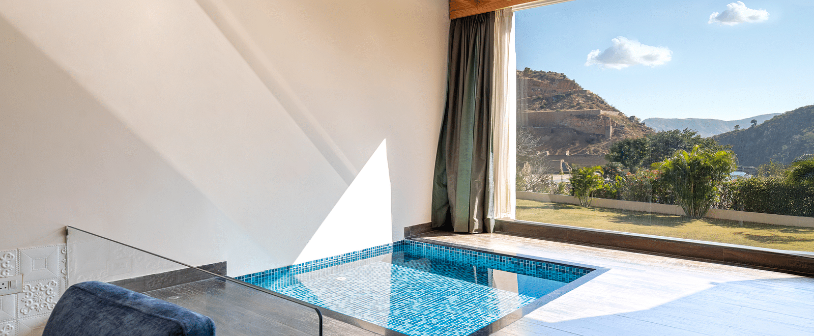 A private plunge pool on a balcony with mountains visible through open wall - Via Lakhela Resort & Spa