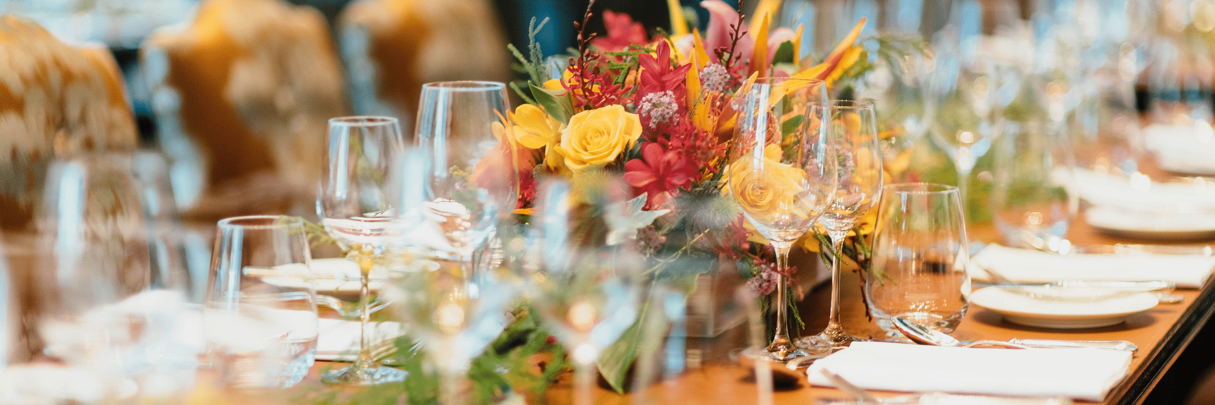 A table with fancy cutlery, glass bottles and decorations during an event