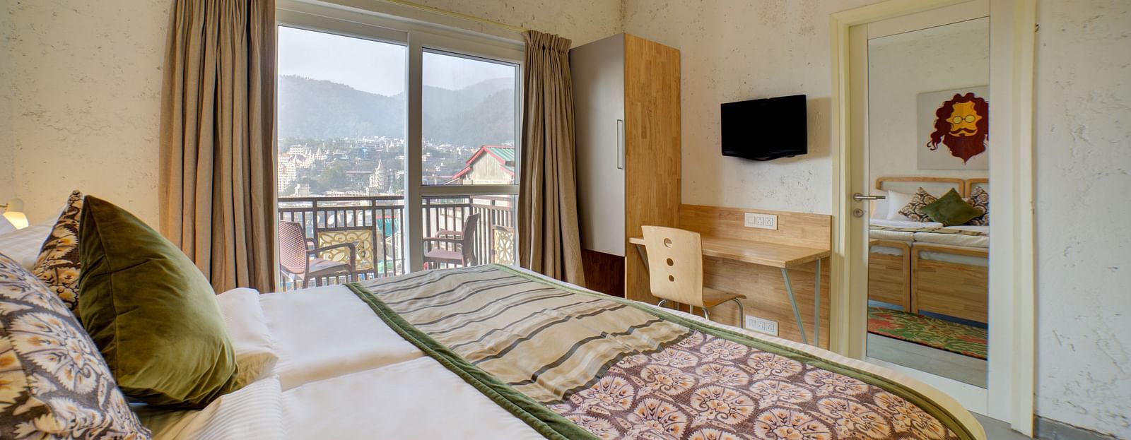 Side view of a room with an air-conditioner and a large bed facing a television - Bedzzz, Rishikesh