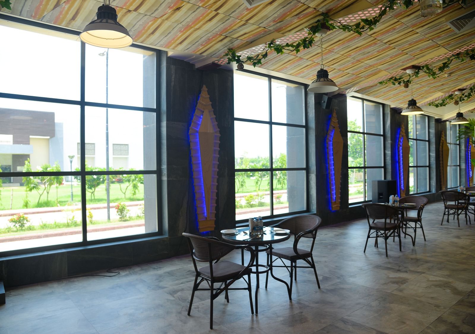 A restaurant with several tables and chairs - Golden Blossom Imperial Resorts, Lucknow