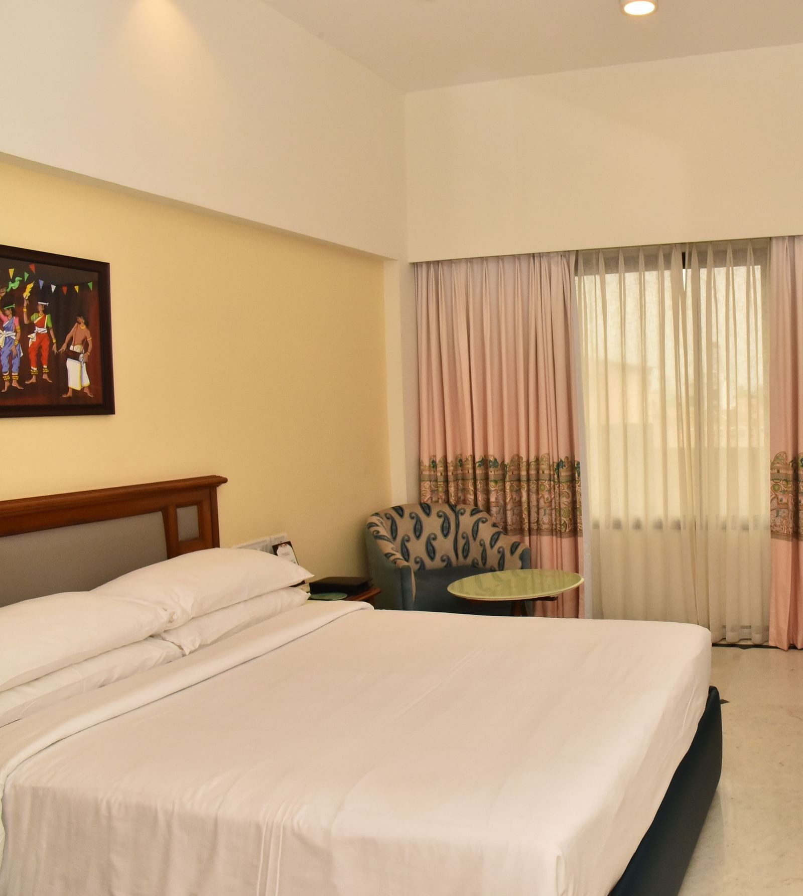 An image of our Deluxe Room featuring a large bed positioned in front of a wall-mounted television - Regency Kanchipuram by GRT Hotels