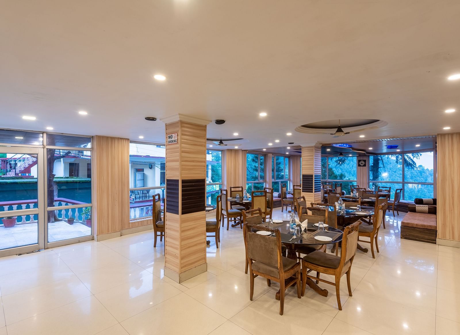 A wide angle shot of the restaurant featuring chairs and tables | DLS Anupam Resort, Dharamshala