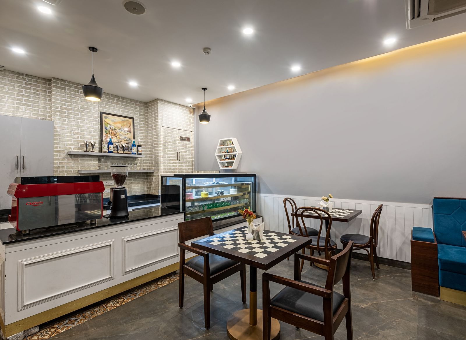 cafe featuring a coffee maker accompanied by an assortment of snacks and pastries neatly arranged in a glass cabinet at DLS The Classio