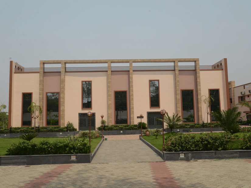 A front-view of the hotel facade with a small manicured garden in front - Wedlock Greens Resort Dhanbad