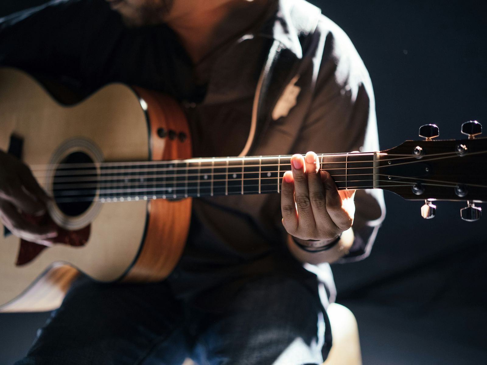 A close up shot of a person playing guitar on stage 
