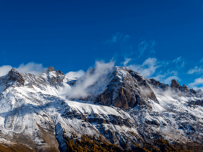 Magnificent snow capped mountains with fog around it