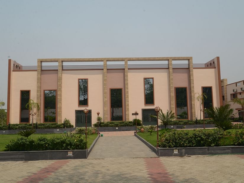 A front-view of the hotel facade with a small manicured garden in front - Wedlock Greens Resort Dhanbad.