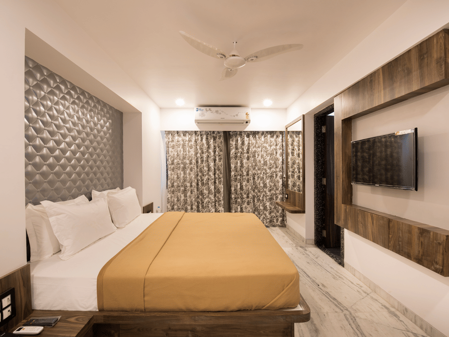 side view of deluxe room at  adamo sanmukh with its clean ambience and modern interior .