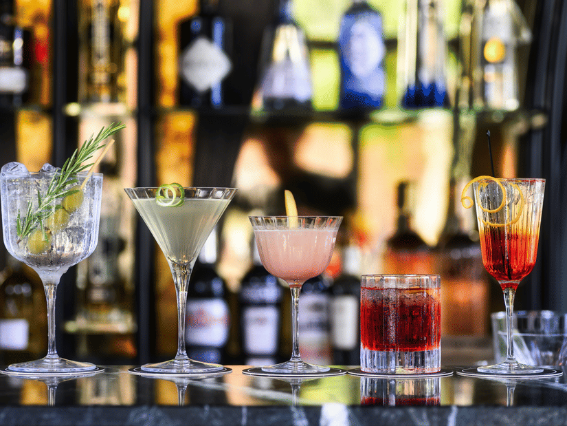 A close up shot of many cocktail drinks placed on the bar counter.