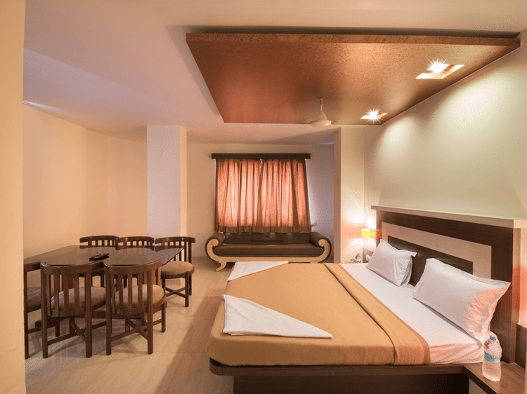 The bedroom offering a bed and a sitting space at the royal suite at Vaikunth by Adamo
