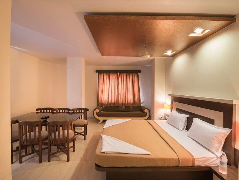 The bedroom offering a bed and a sitting space at the royal suite at Vaikunth by Adamo