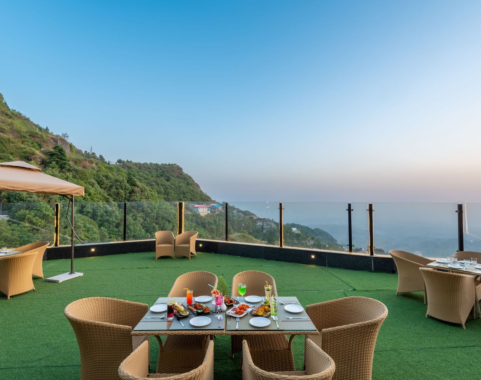 Comfortable seating in the lawn surrounded by hills at dusk at DLS Highland Resort and Spa, Mussoorie.