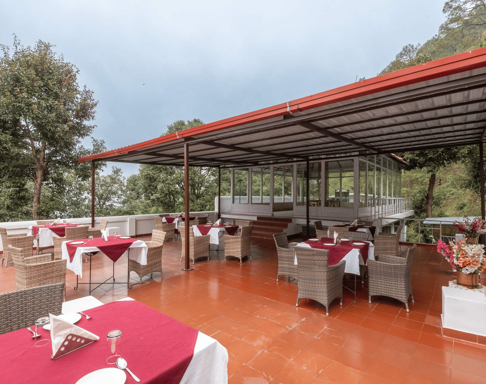 Image of the open air restaurant at DLS Tehri Resort with chairs and tables arranged.