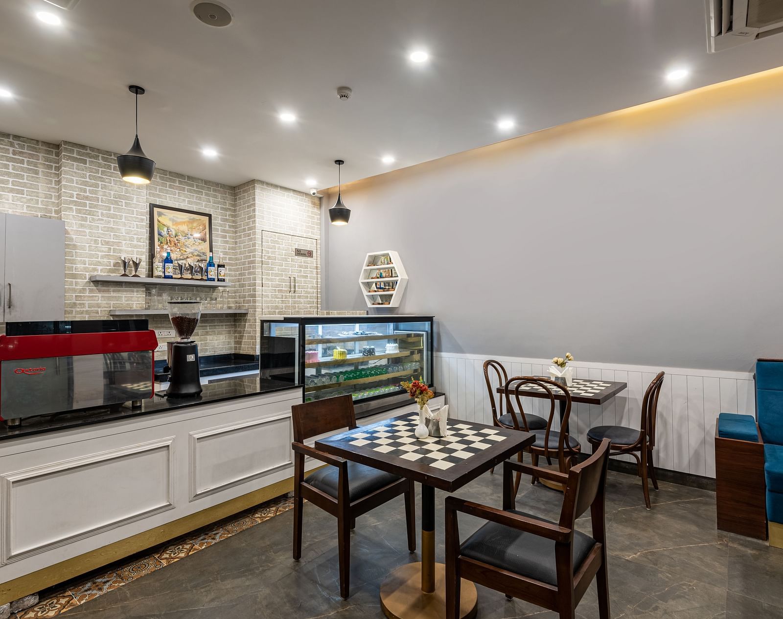 cafe featuring a coffee maker accompanied by an assortment of snacks and pastries neatly arranged in a glass cabinet at DLS The Classio