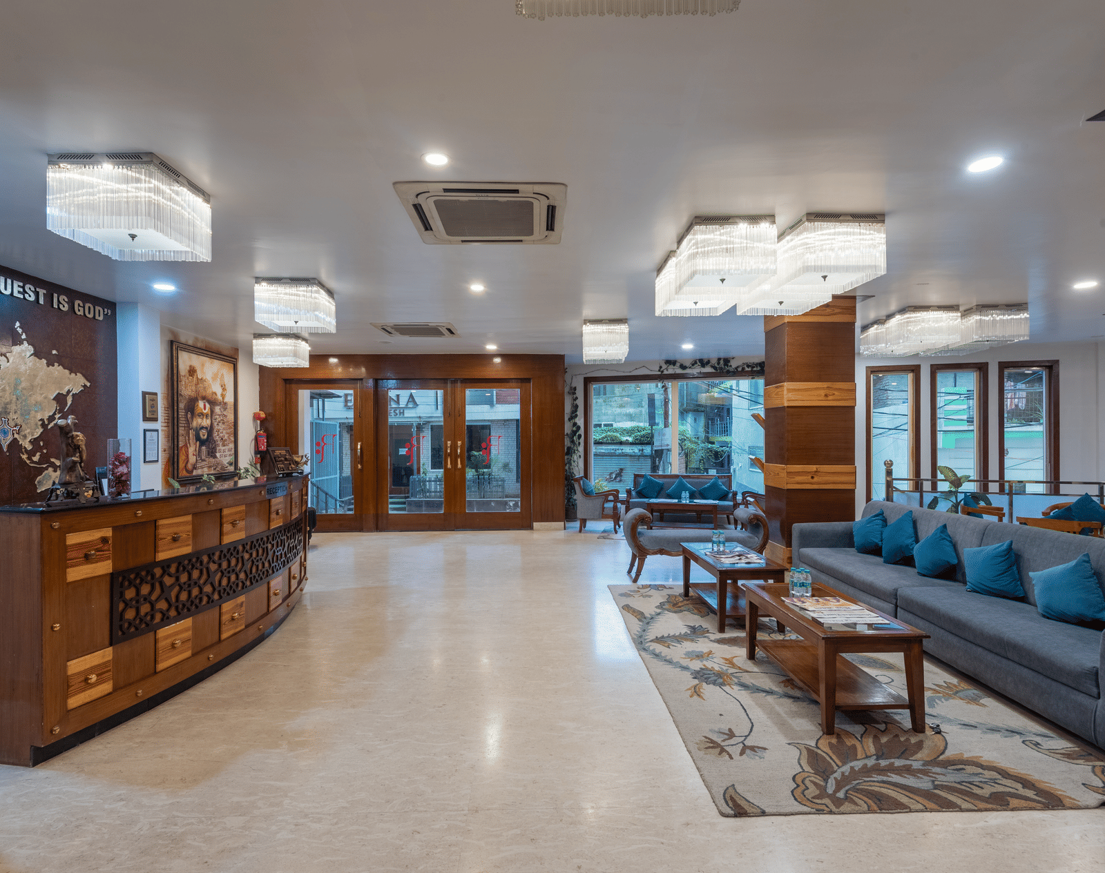 Reception area at DLS Hotels On The Ganges featuring a huge lobby with reception desk on one side, and on the other side there is a seating area with sofa sets. There are also ceiling lights and centralised air conditioners.