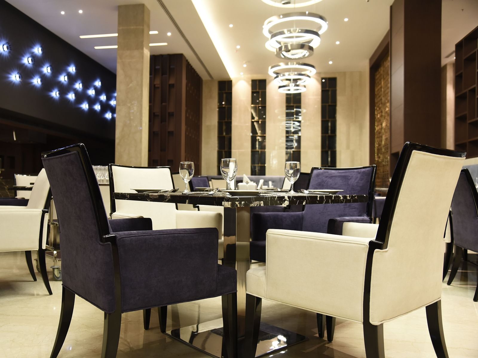  A dining area with warm lighting and inviting décor, where tables are elegantly set for guests to enjoy their meal