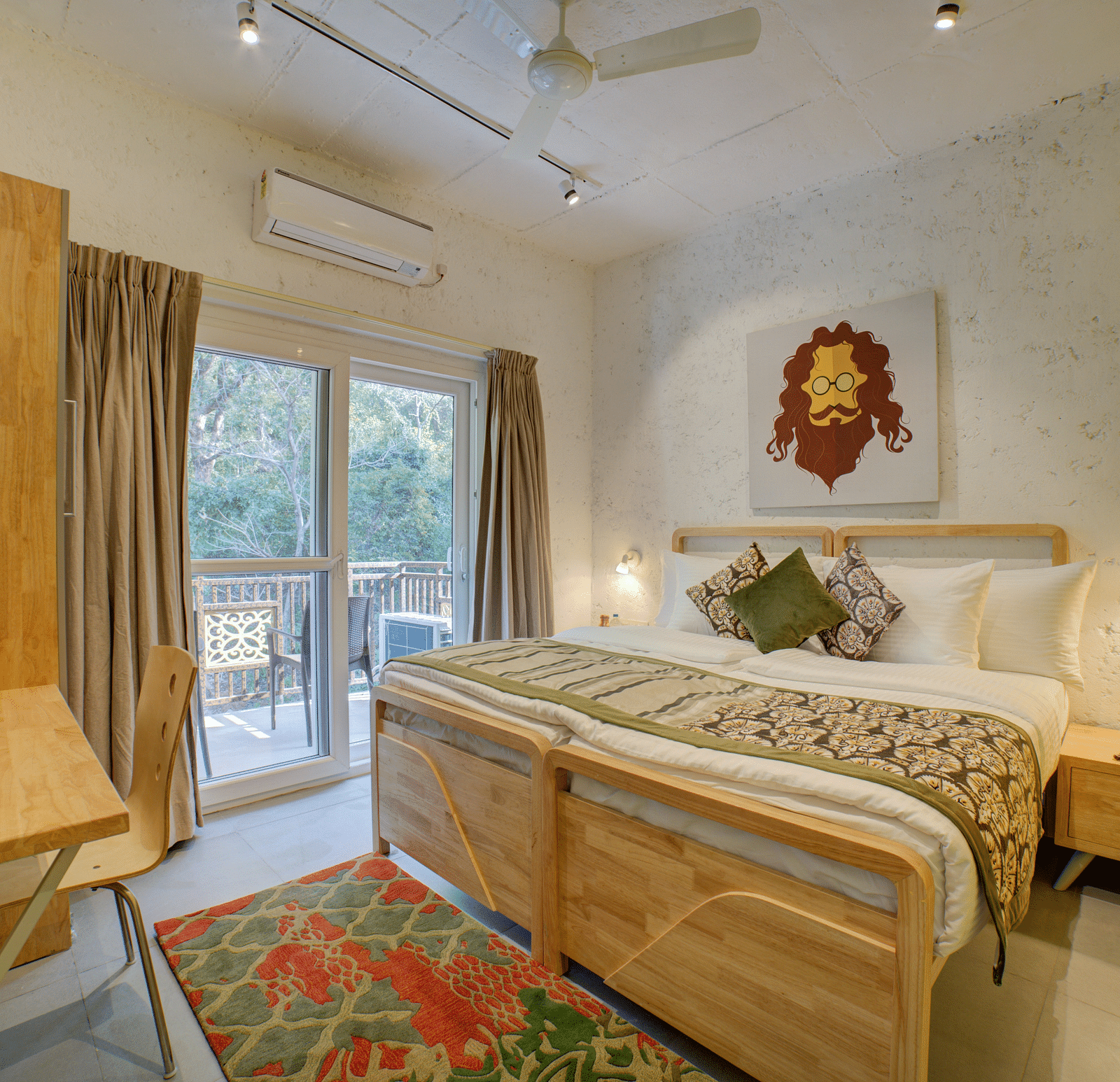 A bedroom with a large bed beside large windows opening into a  balcony with forest views outside - Bedzzz, Rishikesh