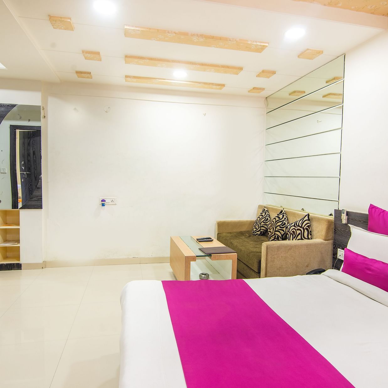 A room featuring a bed, a TV, a coffee table, and a sofa bed - Hotel Morya, Bhopal