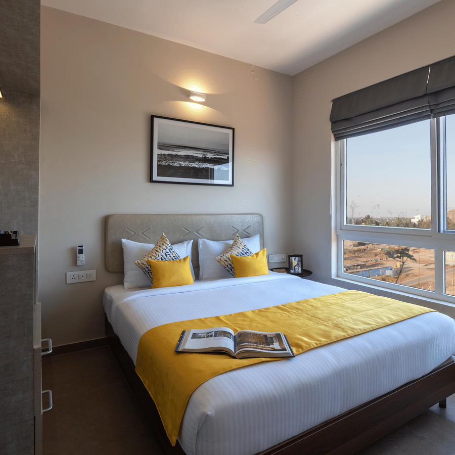 Spacious deluxe room with a large bed, modern interiors, and window view at Avora Tree, a hotel near Bangalore International Airport ideal for comfortable airport stays.