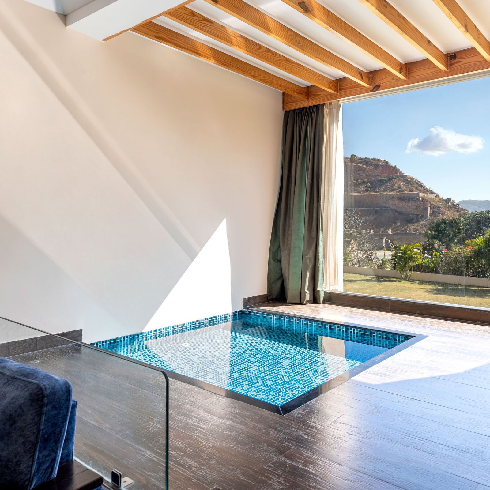 A private plunge pool on a balcony with mountains visible through open wall - Via Lakhela Resort & Spa