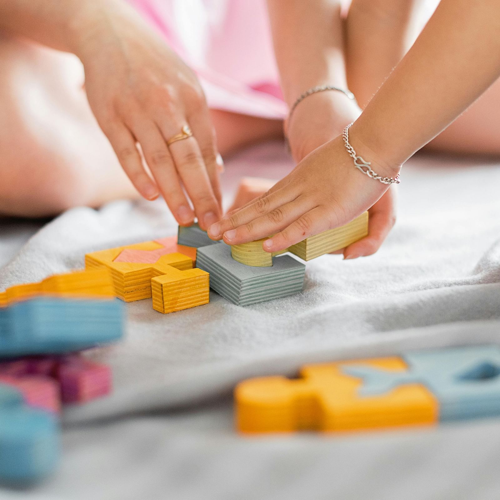 A close up shot of two people playing with puzzle pieces