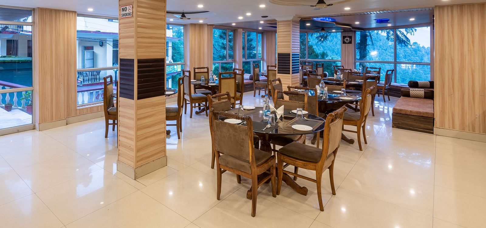 A wide angle shot of the restaurant featuring chairs and tables | DLS Anupam Resort, Dharamshala