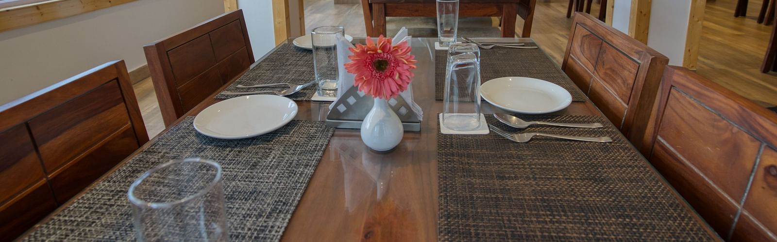 Dining space with seating area and a vase of flower on the table at Gangtok prime