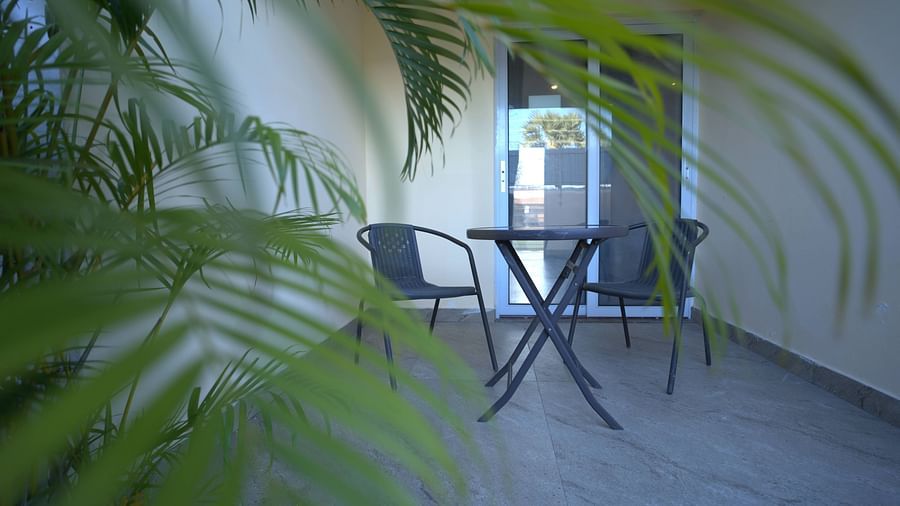 Balcony of Junior Suite at Citrus Classic Resorts and Spa Mahabalipuram ECR featuring a sitting space with a couple of chairs and a coffee table with plants on one side