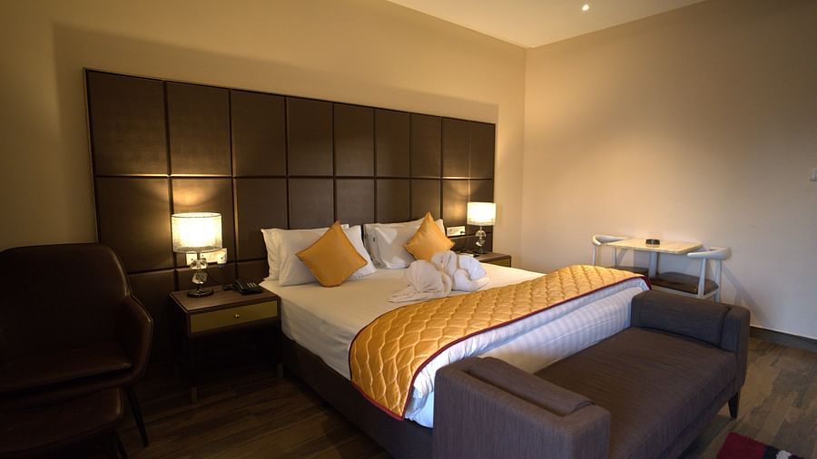 Premium Room at Citrus Classic Resorts and Spa Mahabalipuram ECR featuring a large plush bed with fresh linen and a divan at the foot under warm lighting