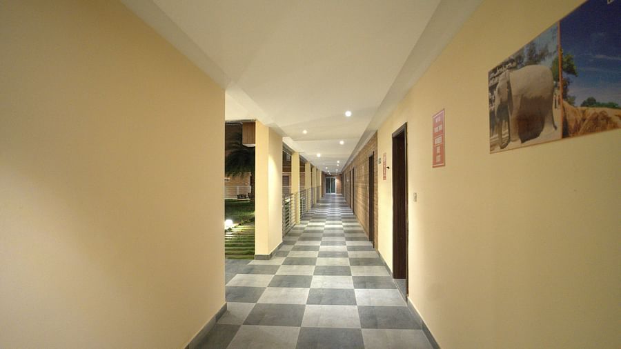 Corridor of Citrus Classic Resorts and Spa Mahabalipuram ECR featuring patterned floor and walls with hangings on them