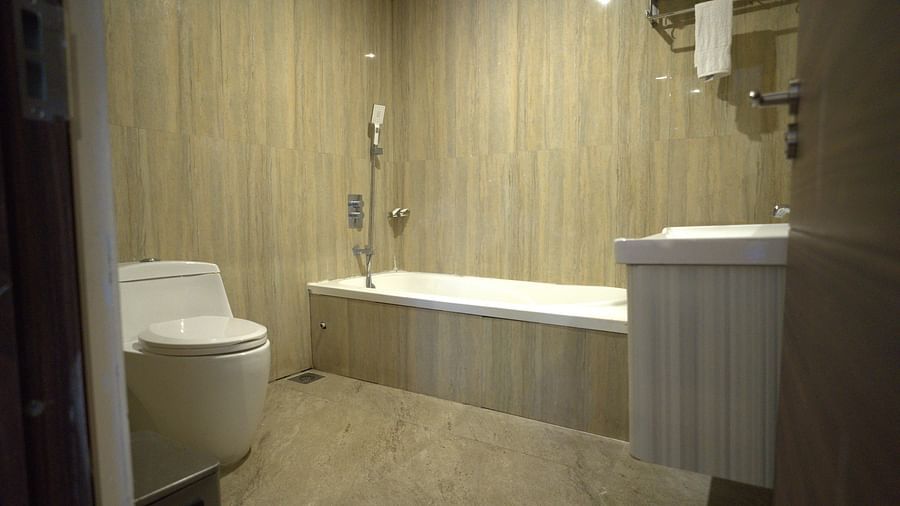 a well lit bathroom of Premium Room at Citrus Classic Resorts and Spa Mahabalipuram ECR featuring a bathtub with a hand shower and a toilet beside it facing in the direction of the sink