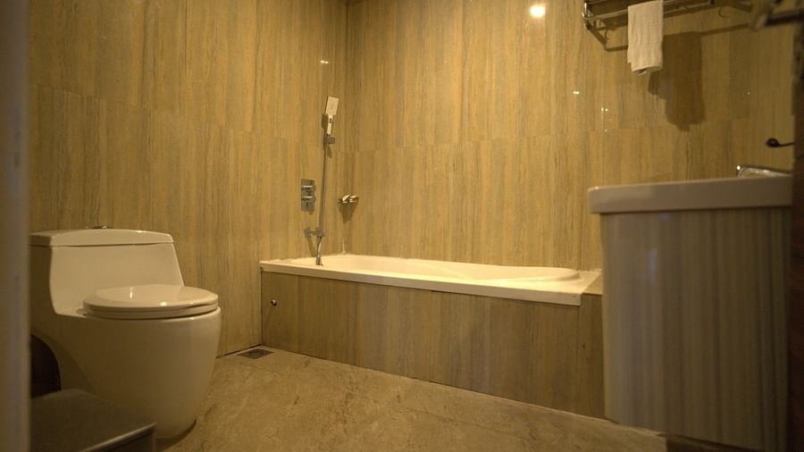 Bathroom of Premium Room at Citrus Classic Resorts and Spa Mahabalipuram ECR featuring a bathtub and a toilet next to it with towels rolled in on the hanger