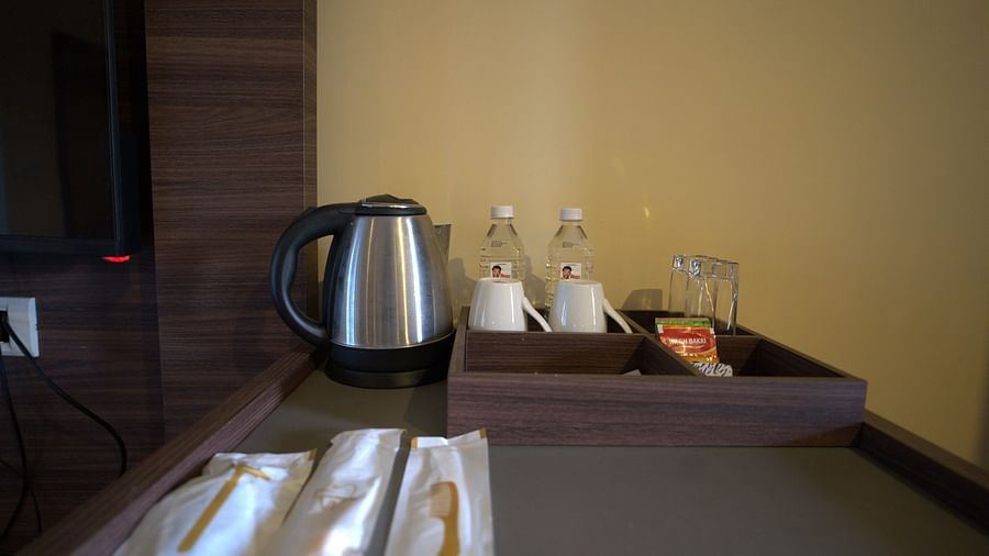 Coffee maker with mugs and water bottles along with glasses and sachets of tea and disposable cutlery in the room at Citrus Classic Resorts and Spa Mahabalipuram ECR