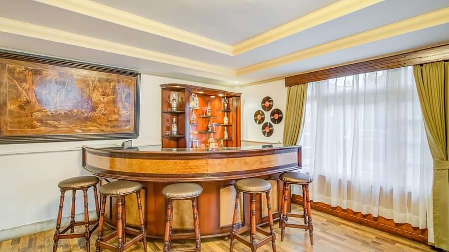 Lounge area with large windows and wooden chiars and floors at Summit Tashi Ghang Heritage Resort, Pelling