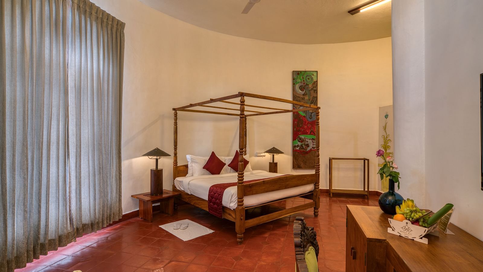 A suite with four-poster bed, large window beside it and a table at the corner | Mango Hill, Yercaud
