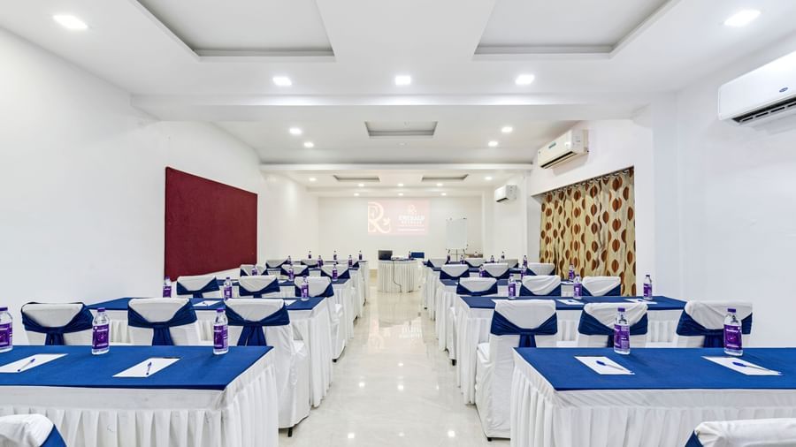 Banquet hall with classroom seating arrangement with blue chair sashes at Emerald Retreat, Tungarli.