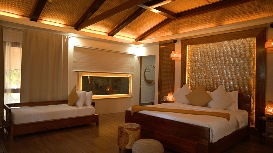 Imperial Villa king bedroom with additional daybed, vaulted native-inspired ceiling, and warm ambient lighting at Flower Island Resort.