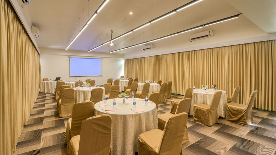 Banquet hall with  white table and golden chairs.