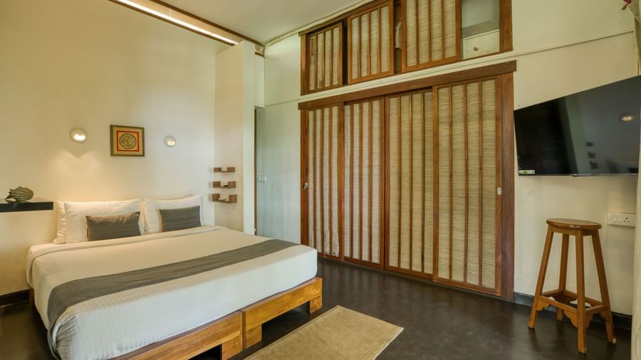 Villa room with a flat screen television, and soft white lights for reading above the bed.