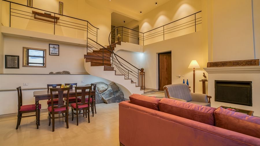 A luxurious living room with attached indoor stairs leading to the first floor | Mango Hill, Yercaud