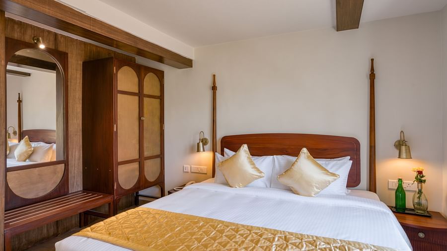A double bed with a wardrobe next to it inside junior suite | Mango Hill Shola Ooty